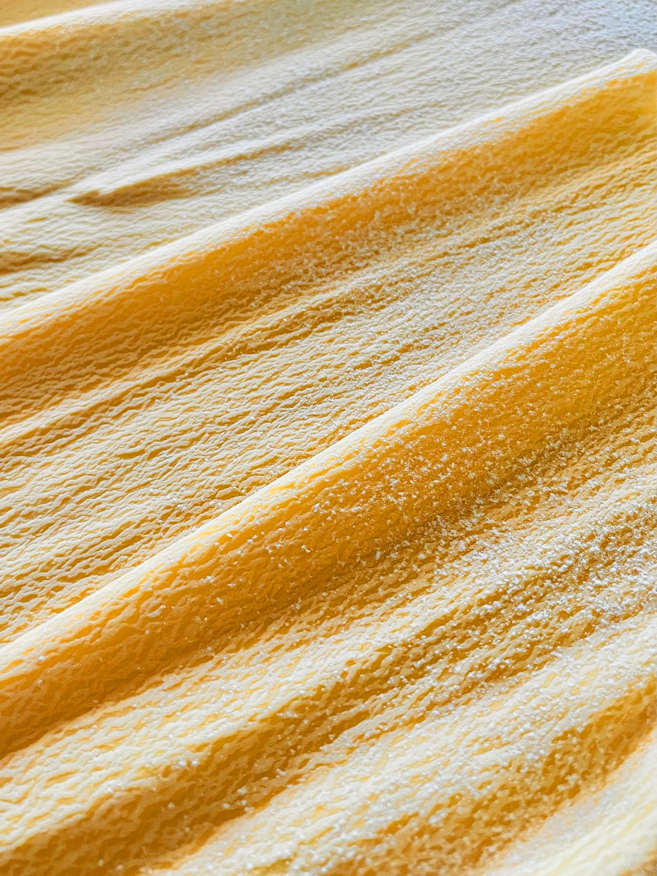Folded sheets of fresh egg pasta dusted with flour